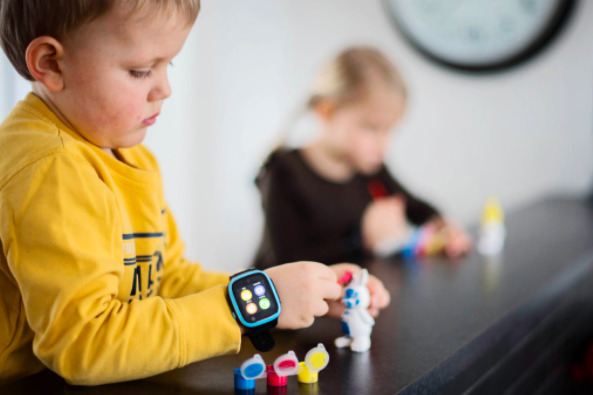 Dreng leger mens han har Xplora smartwatch rundt om håndledet